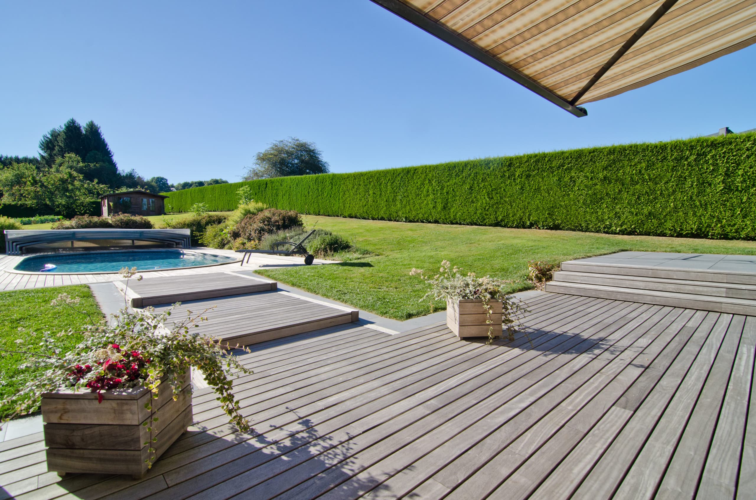 Comfy little decking in a Belgian garden with a pool