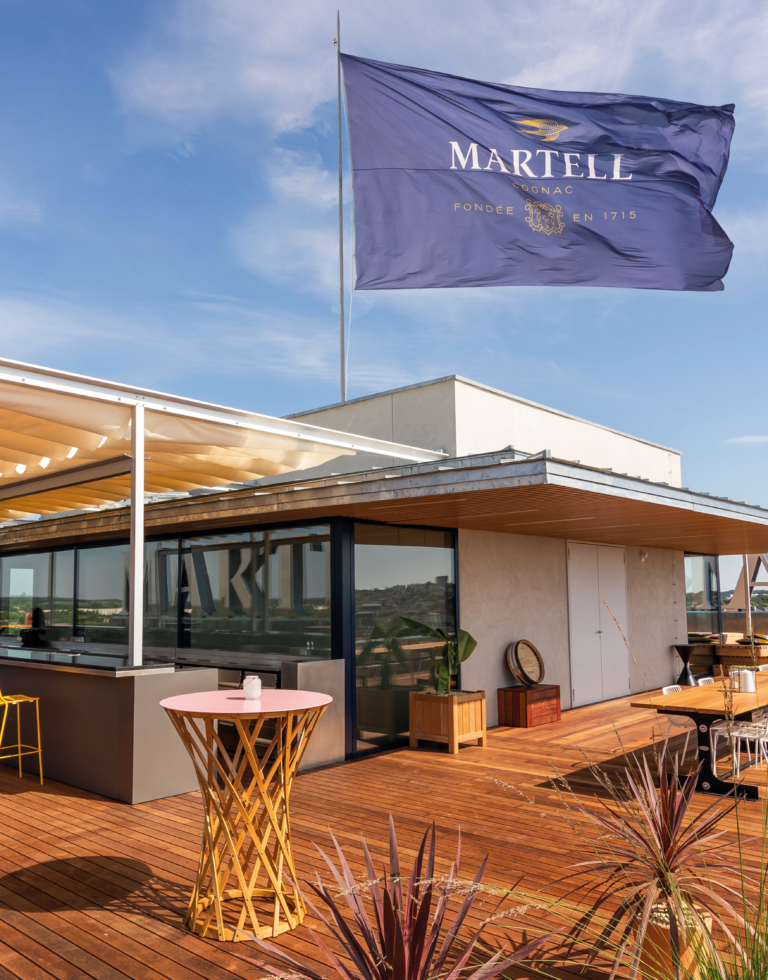 Un drapeau qui flotte dans les air sur la terrasse en bois exotique pour le rooftop de la tour martell à Cognac en france