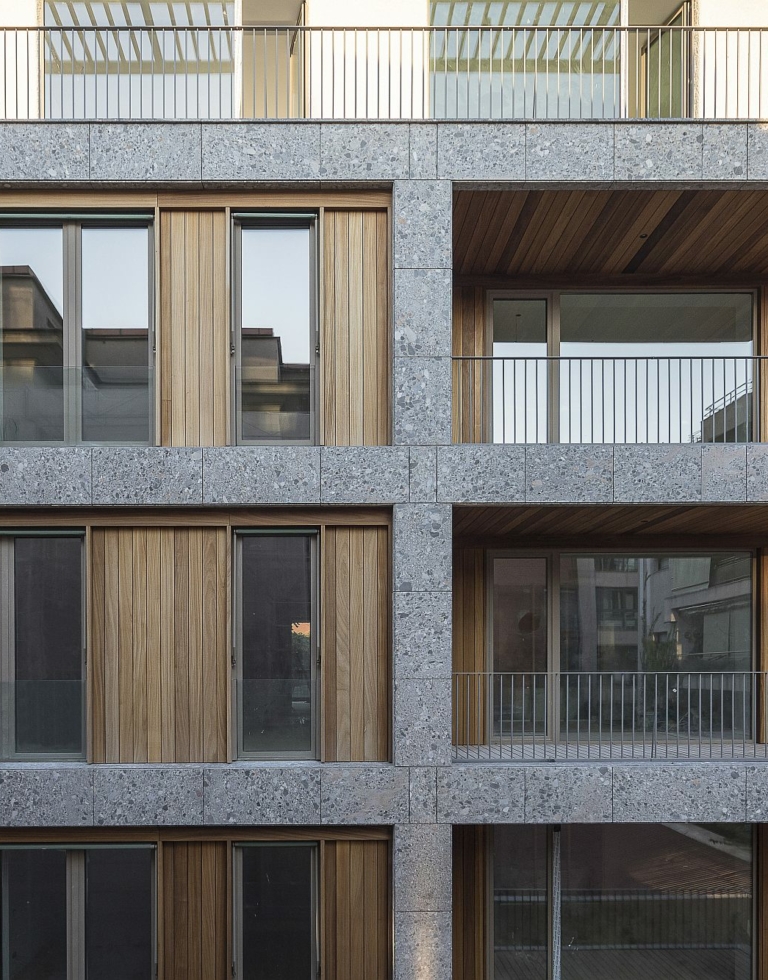 ander balkon van een grijs gebouw met onze bekleding van exotisch hout in ayous met ons technisch systeem