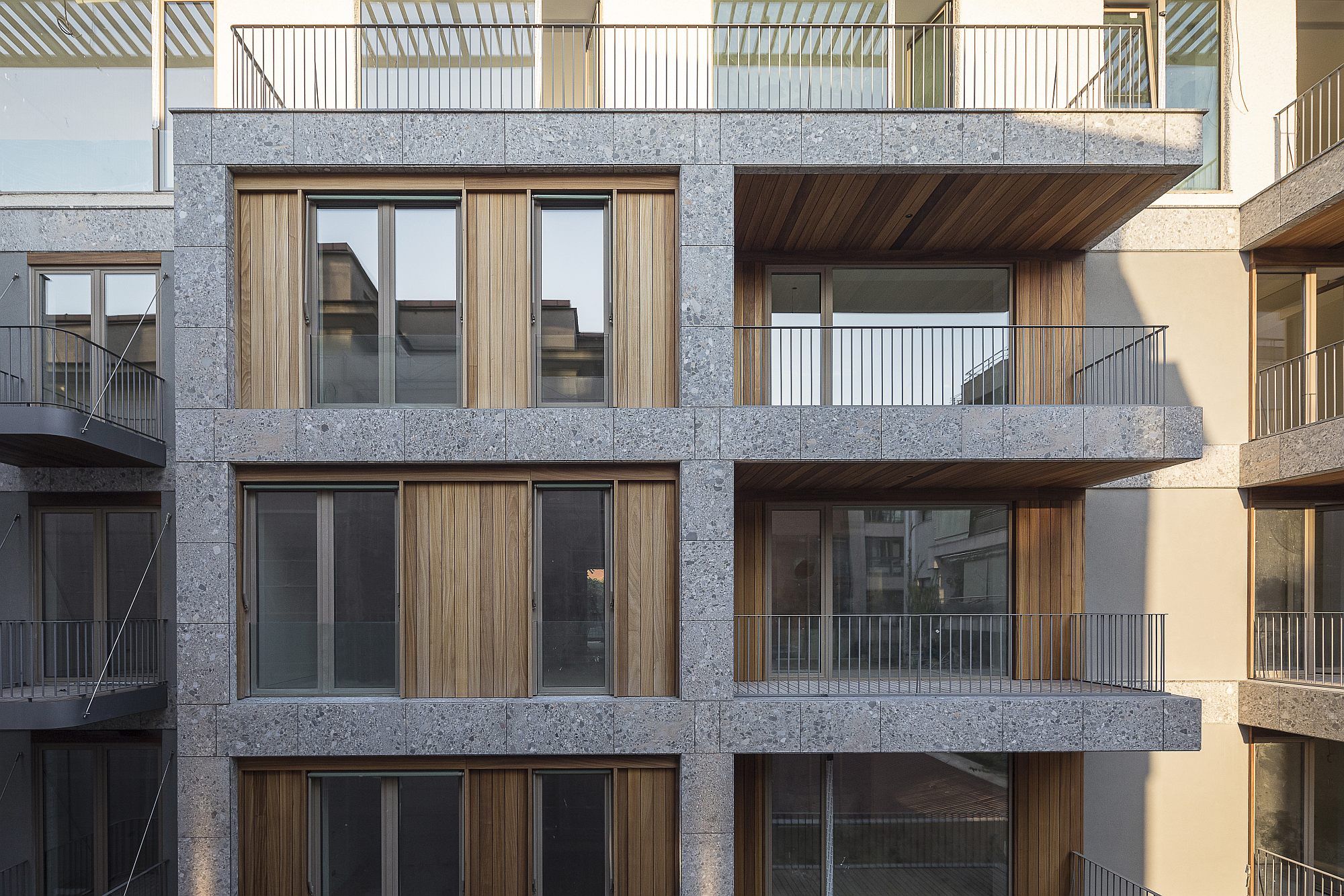 ander balkon van een grijs gebouw met onze bekleding van exotisch hout in ayous met ons technisch systeem