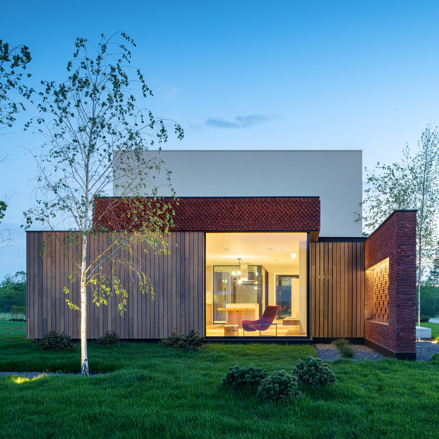 maison moderne avec un joli jardin en roumanie rectangulaire avec un bardage en bois en ayous en début de soirée