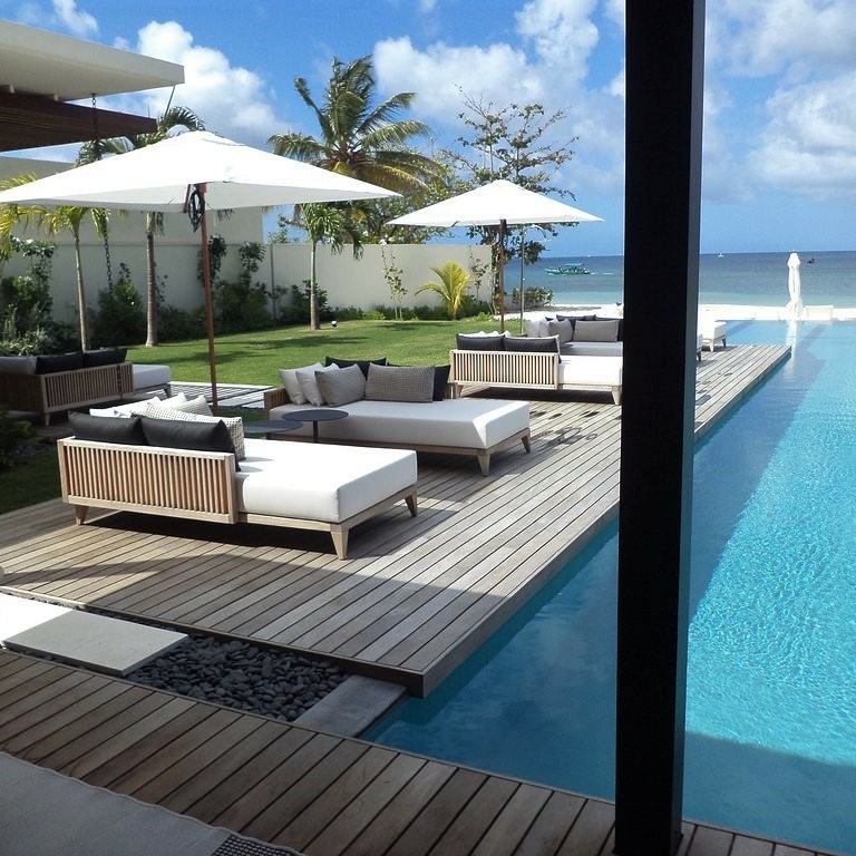 Salon extérieur sur terrasse Softline Ipé+ Teak Silversands Hotel Grenada au bord d'une piscine avec palmiers